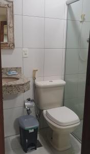 a bathroom with a toilet and a glass shower at Pousada Morada dos Pássaros in Pedro Leopoldo