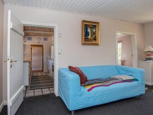 ein Wohnzimmer mit einem blauen Sofa in einem Zimmer in der Unterkunft 7 person holiday home in Grenaa in Grenå