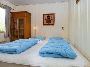 2 duże niebieskie poduszki na łóżku w pokoju w obiekcie 6 person holiday home in R nde w mieście Rønde