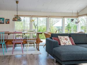 a living room with a couch and a table and chairs at 6 person holiday home in R nde in Rønde