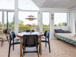 una sala da pranzo con tavolo, sedie e letto di 6 person holiday home in Hornslet a Hornslet