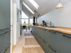 eine Küche mit grünen Schränken und einer hölzernen Arbeitsplatte in der Unterkunft 6 person holiday home in Hornslet in Hornslet