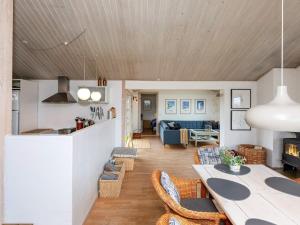 洛肯的住宿－Two-Bedroom Holiday home in Løkken 20，厨房以及带桌椅的起居室。