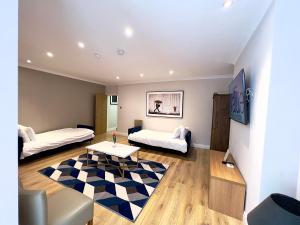 a living room with two beds and a table at The Beverley Apartments London - Victoria in London