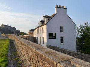 a stone retaining wall next to a building at Kestrel Cottage - 27937 in Cambusbarron