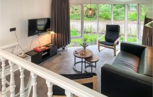 uma sala de estar com um sofá e uma televisão em Amazing Home In Beekbergen With Outdoor Swimming Pool, Wifi And 2 Bedrooms em Beekbergen