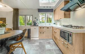 a kitchen with wooden cabinets and a table at Amazing Home In Beekbergen With Outdoor Swimming Pool, Wifi And 2 Bedrooms in Beekbergen