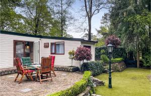 a patio with chairs and a table in a yard at Amazing Home In Beekbergen With Outdoor Swimming Pool, Wifi And 2 Bedrooms in Beekbergen