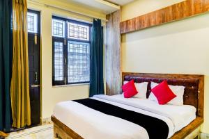 KotdwāraにあるCapital O 66972 Sangam Hotel And Resortのベッドルーム1室(大型ベッド1台、赤い枕付)