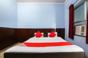 um quarto com uma cama grande e almofadas vermelhas em OYO 67226 Om Hotel em Neemrana
