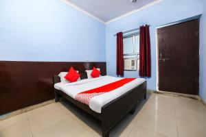 um quarto com uma cama com almofadas vermelhas em OYO 67226 Om Hotel em Neemrana