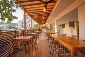 una fila de mesas y sillas en el balcón de un restaurante en Aventureros 360 Alojamiento & Tours, en Gaira
