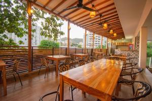 een restaurant met houten tafels en stoelen en een groot raam bij Aventureros 360 Alojamiento & Tours in Gaira