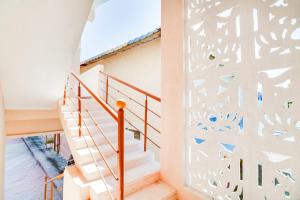 a staircase with a white wall with a mural of birds at OYO 68320 Bgr Residency in Tirupati