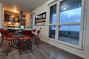 a kitchen with a table and chairs and a large window at Appartement standing proche Arena Paris La Défense in Nanterre