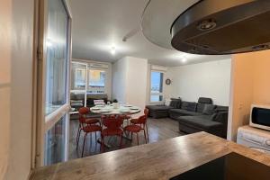 a kitchen and living room with a table and chairs at Appartement standing proche Arena Paris La Défense in Nanterre