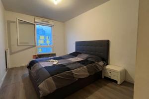a bedroom with a bed and a window at Appartement standing proche Arena Paris La Défense in Nanterre