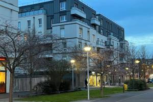 a large white building with street lights in front of it at Appartement standing proche Arena Paris La Défense in Nanterre