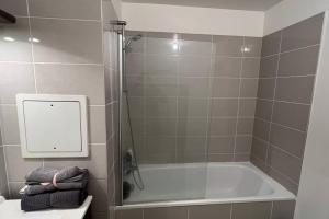 a bathroom with a shower and a bath tub at Appartement standing proche Arena Paris La Défense in Nanterre +12 photos