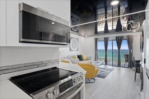 a kitchen with a stove top oven next to a living room at The Summit 702 in Panama City Beach