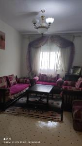 a living room with pink furniture and a chandelier at شقة من غرفتين نوم وصالة in Tangier