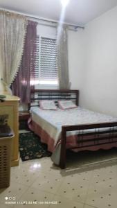 a bedroom with a bed and a window at شقة من غرفتين نوم وصالة in Tangier