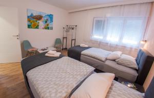 um quarto com três camas e uma mesa e cadeiras em Candy Loft Apartment em Mostar