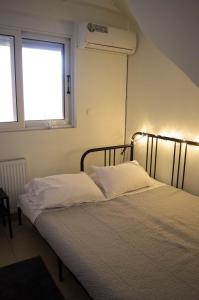 sypialnia z 2 łóżkami i oknem w obiekcie Blue and White w mieście Schinias