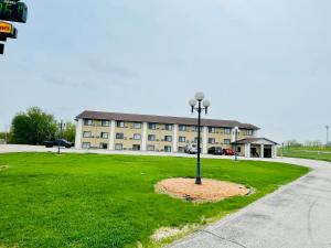 a building with a light pole in the grass at Super 8 by Wyndham Clear Lake in Clear Lake