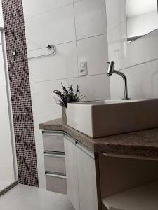 a bathroom with a sink and a shower at Hotel APART Zuccolotto 303 in Aracruz