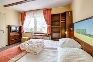a bedroom with a large bed with towels on it at Sommer Residence Hotel&Spa in Kluczbork