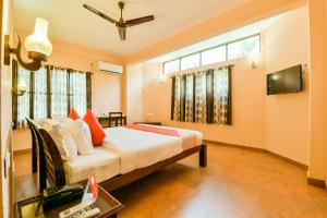 1 dormitorio con 1 cama y TV de pantalla plana en OYO 13415 Cherai Village Home Stay en Cherai Beach