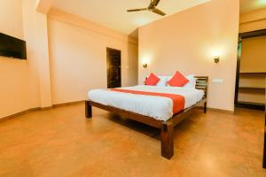 1 dormitorio con 1 cama grande con almohadas rojas en OYO 13415 Cherai Village Home Stay en Cherai Beach