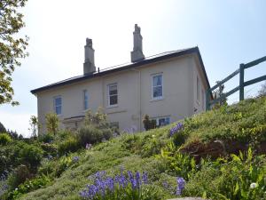 a house on top of a hill with purple flowers at Foxglove in Shaldon