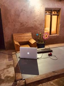a table with a laptop computer and a keyboard at Refugio Andino con vista al volcán. in San Pedro de Atacama +10 photos