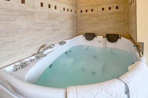 y baño con bañera y paredes de madera. en Sommer Residence Hotel&Spa en Kluczbork