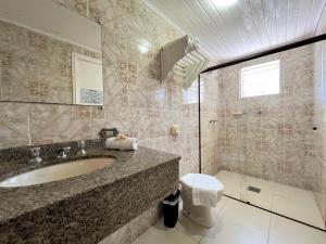 a bathroom with a sink and a shower at Hotel Solar da Montanha in Campos do Jordão