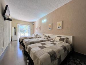 a row of beds in a room at Hotel Solar da Montanha in Campos do Jordão