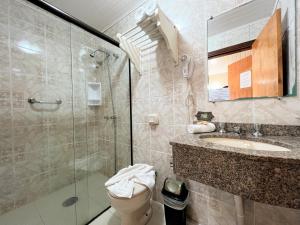 a bathroom with a shower and a toilet and a sink at Hotel Solar da Montanha in Campos do Jordão