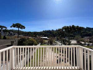 a white railing on a balcony with a view of a town at Hotel Solar da Montanha in Campos do Jordão