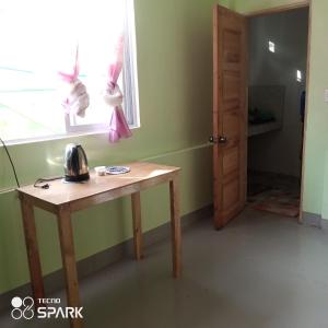 マンバヤオにあるLucky777 Homestayの木製テーブルと窓が備わる客室です。