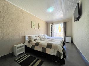 a bedroom with a bed and a television in it at Hotel Solar da Montanha in Campos do Jordão