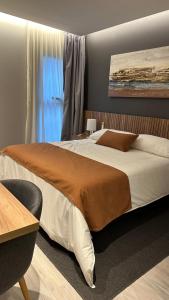 ein Schlafzimmer mit einem großen Bett und einem Fenster in der Unterkunft Urban Suites Oliva in Oliva