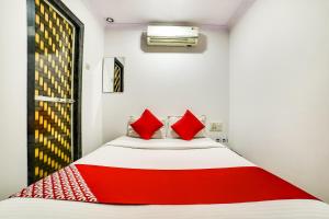 a red and white bed in a white room at OYO 66982 Hotel Skyway Inn in Mumbai