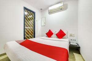 a bedroom with a large bed with red pillows at OYO 66982 Hotel Skyway Inn in Mumbai