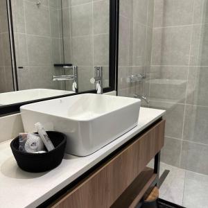 a bathroom with a white sink and a shower at Urban Suites Oliva in Oliva