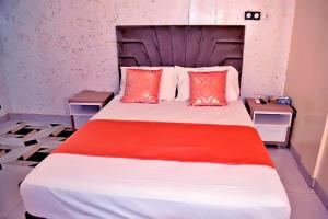 a bedroom with a large bed with red pillows at Complexe Hôtelier AnD in Ouagadougou