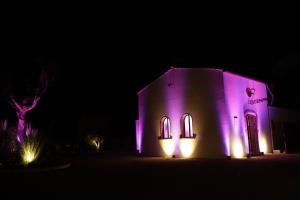 Eine Kirche leuchtet nachts in Lila in der Unterkunft Casabianca Resort in Fondi