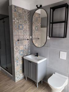 ein Badezimmer mit einem Waschbecken, einem WC und einem Spiegel in der Unterkunft Apartments by the sea Tribunj, Vodice - 12144 in Tribunj