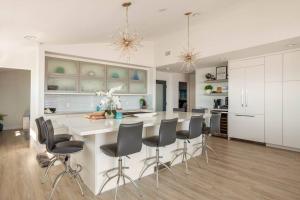 una cocina con una gran isla blanca con sillas en New Luxury Ocean View Penthouse - Del Mar, en Solana Beach